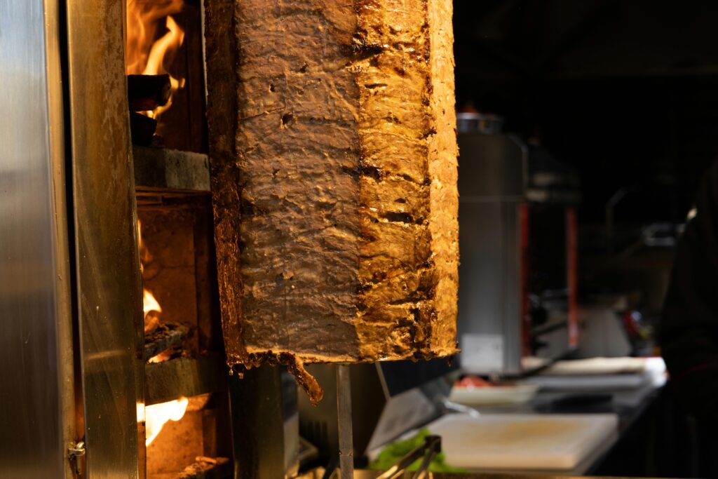pexels-photo-10572741-10572741 Juicy shawarma cooking on a vertical rotisserie, capturing the essence of Turkish cuisine.